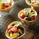 Mini tortilla cups filled with a taco flavored cream cheese, black beand and lots of veggies! www.lemonsforlulu.com