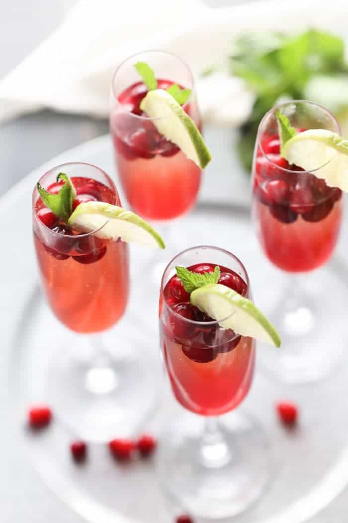 Champagne cocktail recipe with cranberry simple syrup, cranberry juice, vodka and of course champagne! lemonsforlulu.com