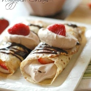 Easy crepes filled with a light Nutella whipped cream and lots of fresh strawberries! www.lemonsforlulu.com