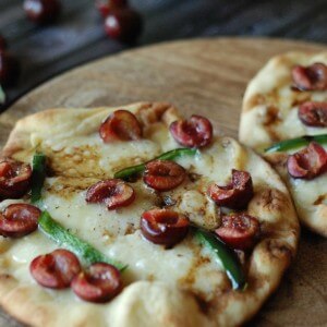 Naan bread is the crust for this tasty pizza. It’s then topped with creamy brie, fresh , tart cherries and crisp poblano peppers! www.lemonsforlulu.com