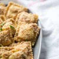 Baked breaded ravioli appetizer with a smokey almond breading and served with a ranch flavored white bbq sauce. lemonsforlulu.com