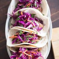 Grilled steak tacos have a fusion flair! Ginger infused cabbage and garlic beans make these tacos full of flavor!