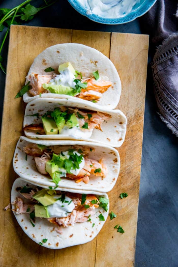Salmon tacos are one of my favorite summertime meals! They are the perfect light dinner! These tacos are made with spicy salmon and are topped with a jalapeno cream! topped grilled salmon tacos