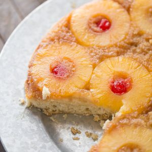 Upside down cake takes a tropical turn! This easy cake recipe has pineapple and cherries resting in a caramel sauce while the cake itself has shredded coconut and a hint of rum!