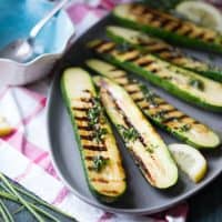 Grilled zucchini is drizzled with fresh herbs and butter for a satisfying side dish that everyone will love!