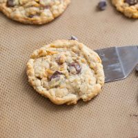 Butterfinger cookies on a baking dish surrounded by big chocolate chips.