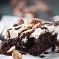 This Snickers poke cake begs for a tall glass of milk! This chocolate cake is so sinfully delicious!