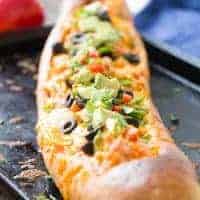 This chicken enchilada bread makes dinner simple! Chicken and sauce are stuffed inside French bread and baked! You decide on the toppings!
