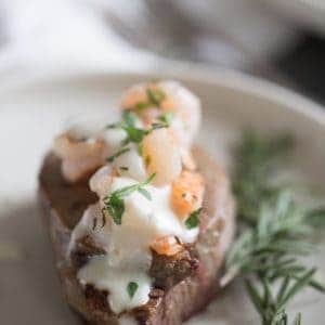 steak on a plate with shrimp on top