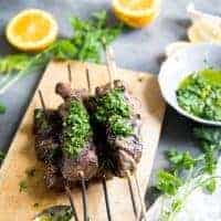 Beef shish kabobs with chimichurri sauce on beef and on the side