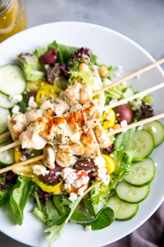 I love serving my family simple chicken recipes. This Greek chicken souvlaki recipe is exactly that! It's light and healthy but so flavorful, especially atop this Mediterranean salad! chicken souvlaki over salad