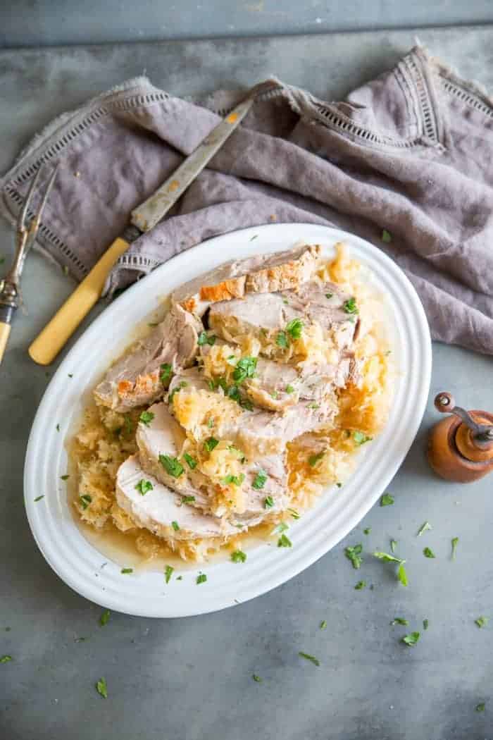 Pork and sauerkraut is a no-fail recipe when you have your slow cooker! This recipe is easy and mouth-watering! pork and sauerkraut with fork and knife